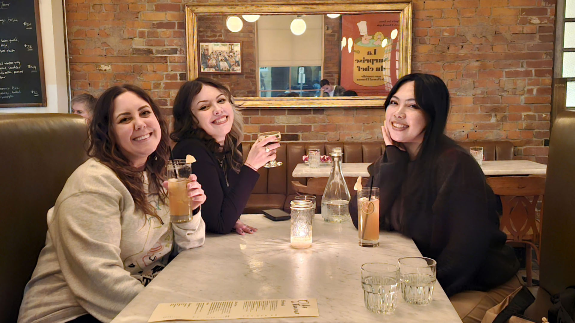 Lauren and friends sitting in the booth at Le Tambour