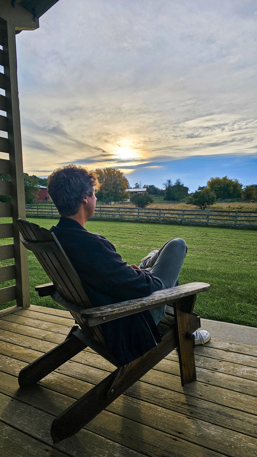 Justin sitting on the porch of our Tiny House at Farm Sanctuary